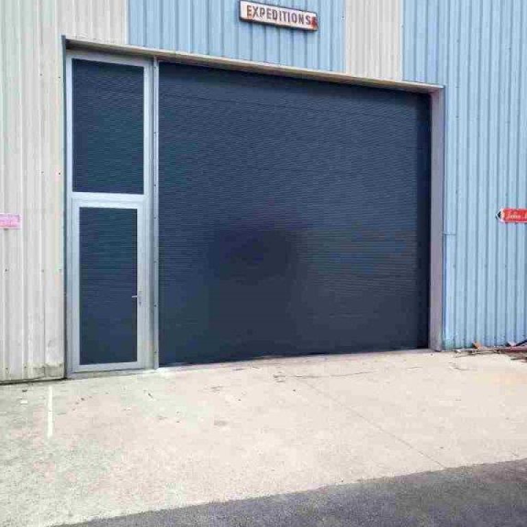porte sectionnelle avec portillon adjacent et imposte isolé vue extérieur sur expédition site industriel